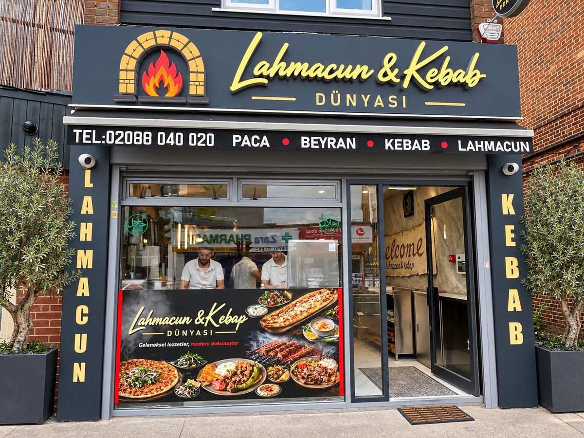 Lahmacun & Kebab Dünyası dükkân cephesi: sarı tabela, iki yanda zeytin ağaçları, vitrinde ustalar